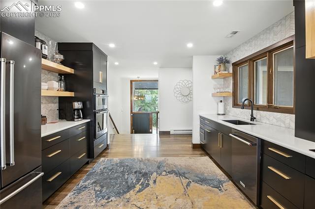 Kitchen featuring open shelves, backsplash, dark cabinets, appliances with stainless steel finishes, and modern cabinets