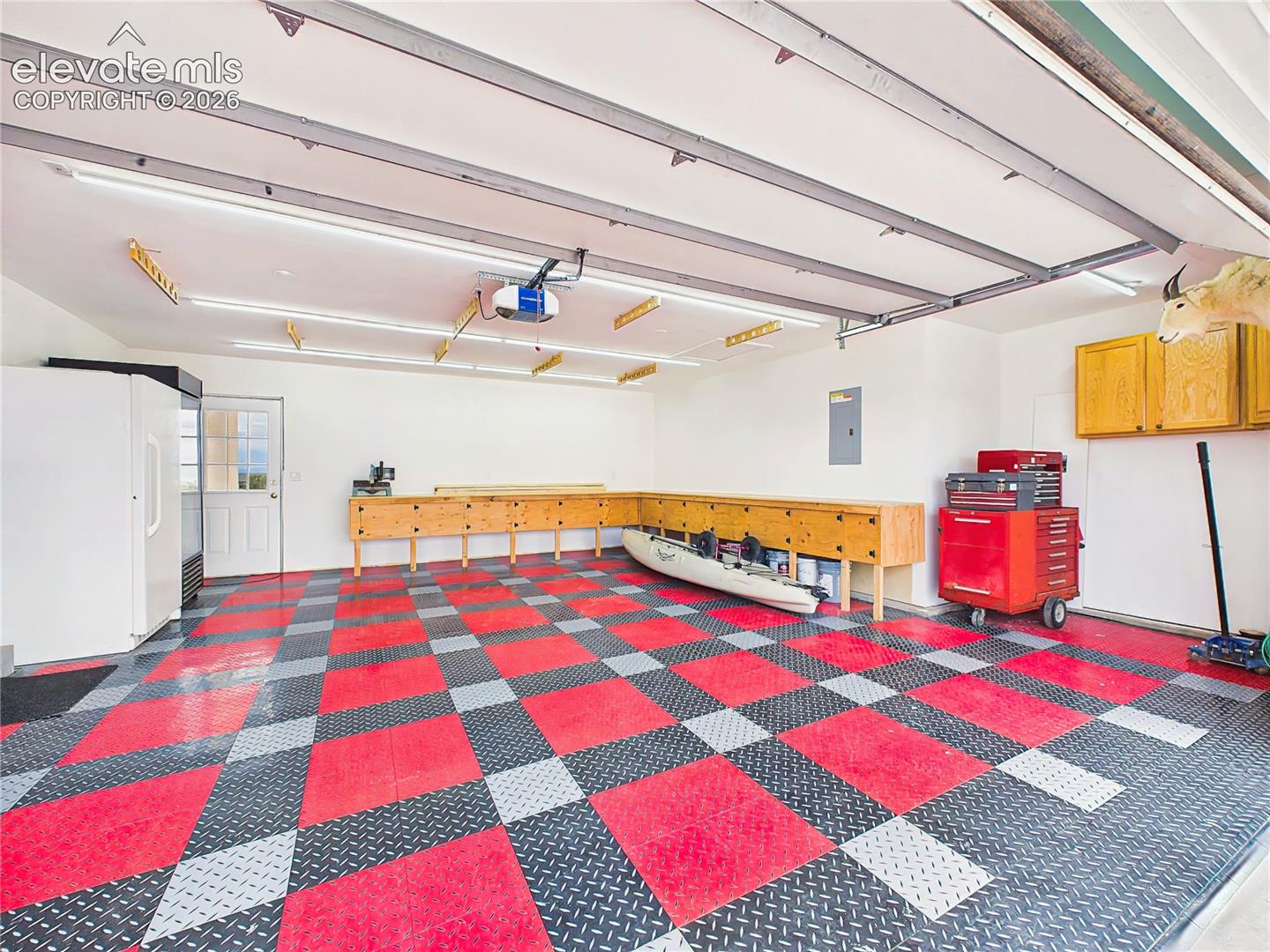 Exceptional oversized garage features custom workbenches, extensive storage solutions, bright lighting, and durable flooring, making it ideal for hobbies, projects, and equipment storage.