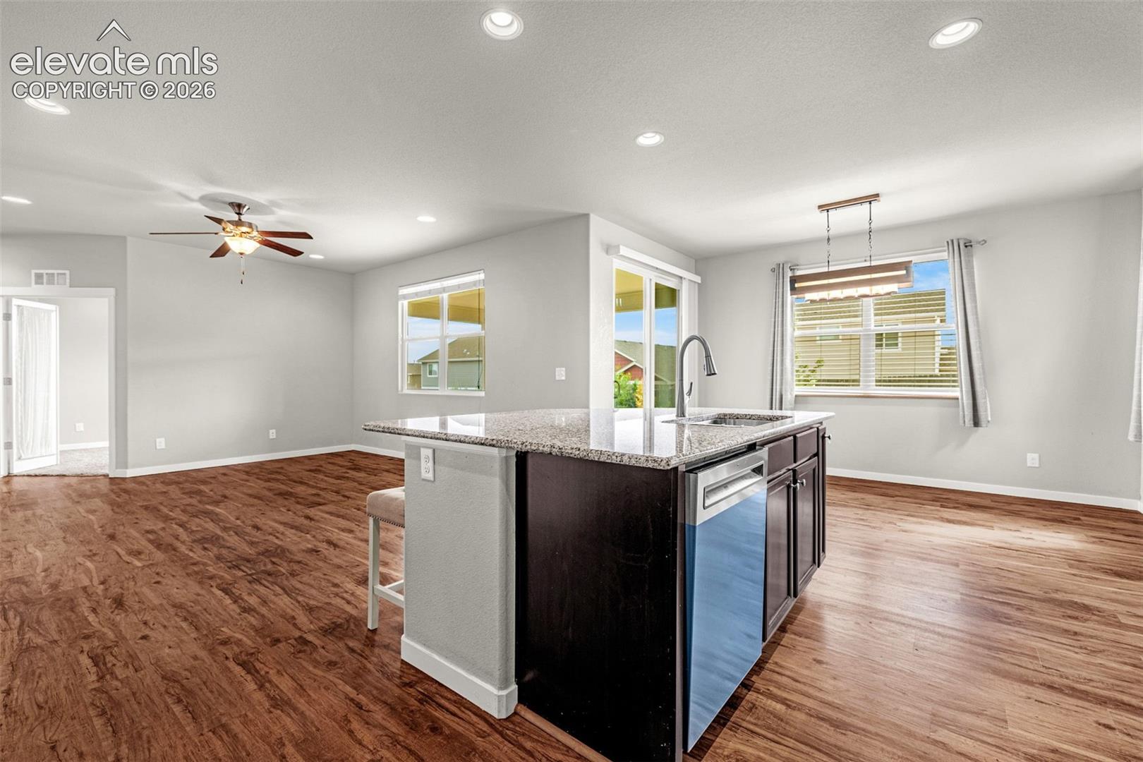 Open-concept living space featuring wood-finish flooring, recessed lighting, and a ceiling fan