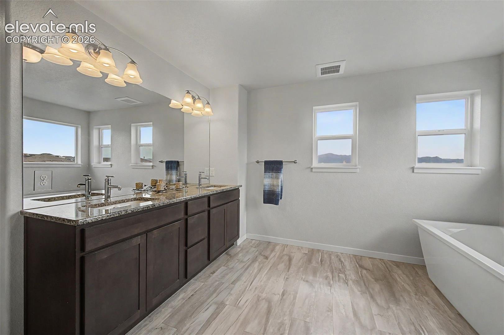 A granite topped double vanity provides so much storage in the primary bath.