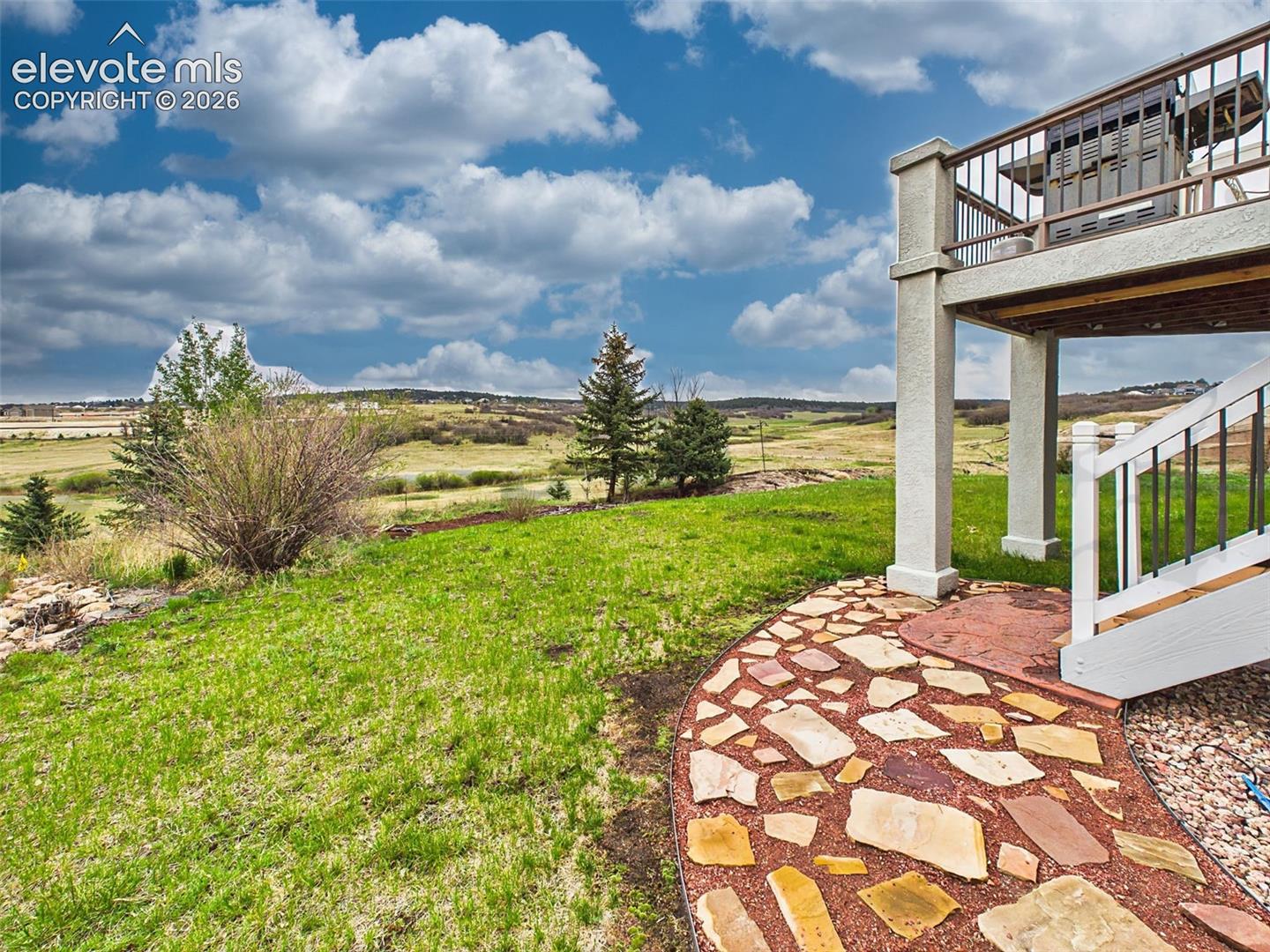 Expansive backyard with custom stone pathways and direct access to wide-open natural surroundings.