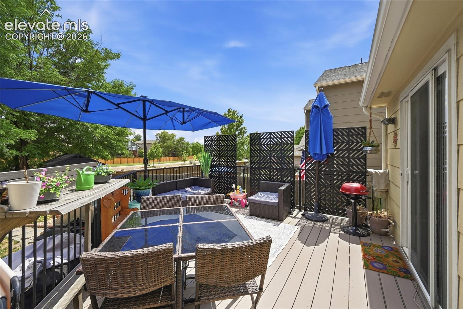 Elevated deck featuring composite decking, metal railing, and geometric privacy screens