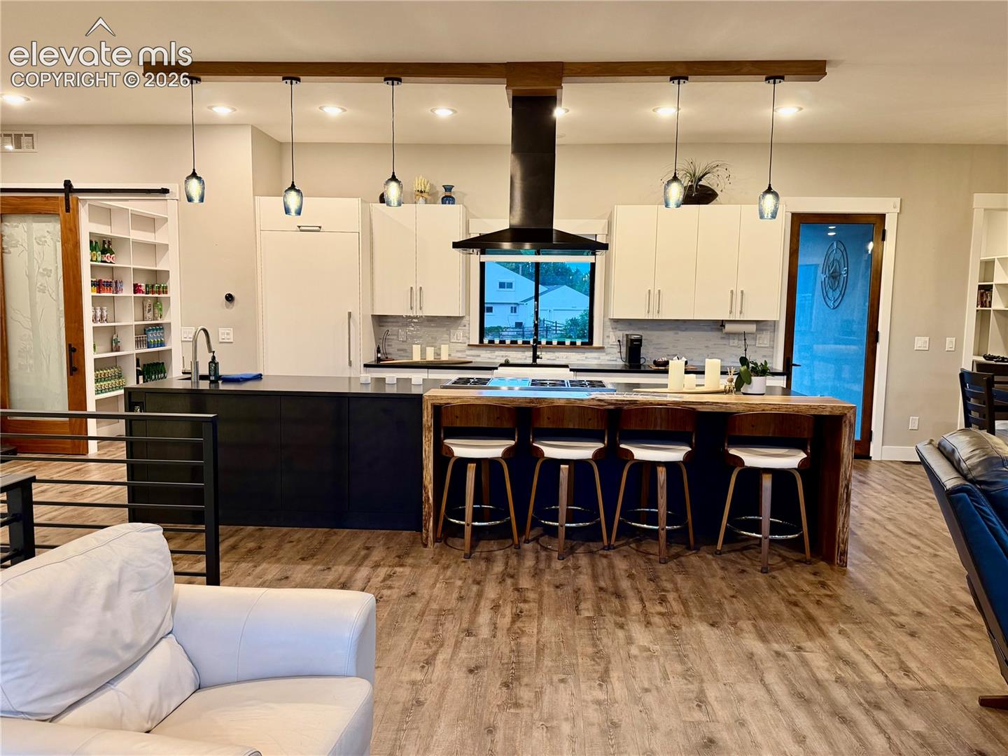 Wood-finish flooring throughout, kitchen with contrasting cabinetry and a custom wood island