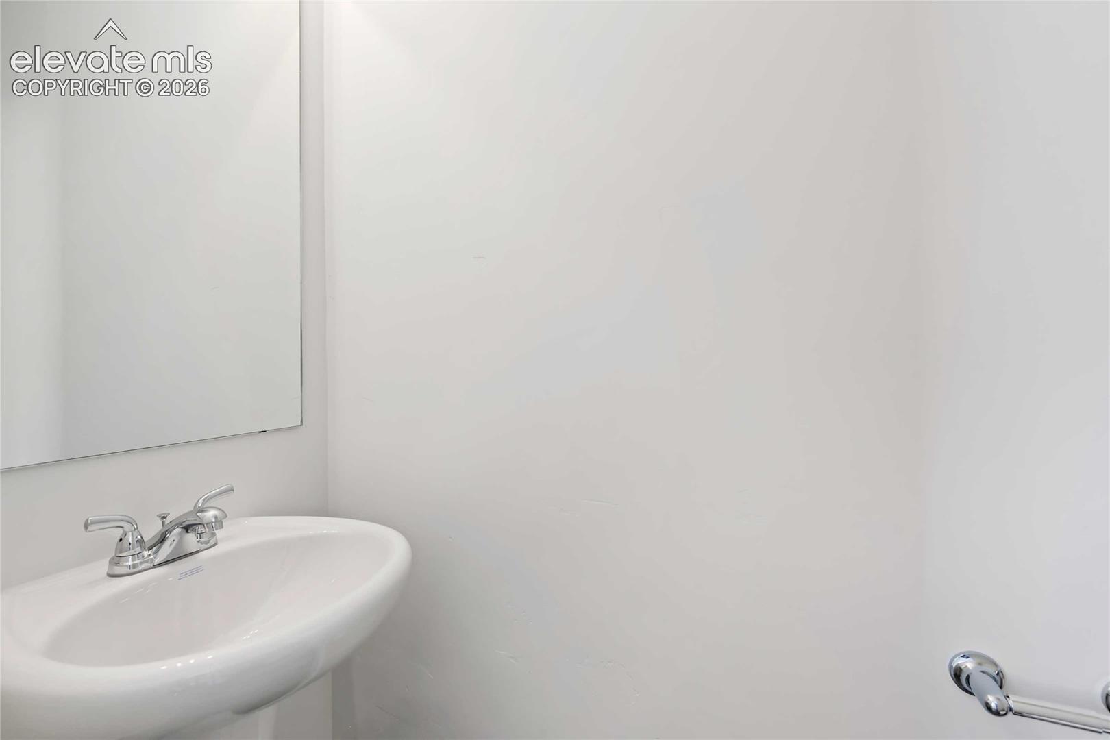 White pedestal sink with chrome faucet and rectangular wall-mounted mirror
*photos of a model home*