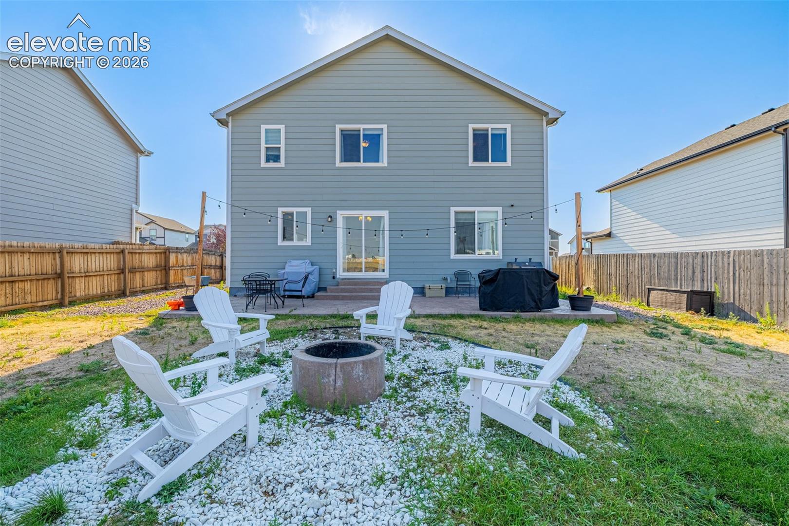 Rear exterior featuring gray siding and white trim windows