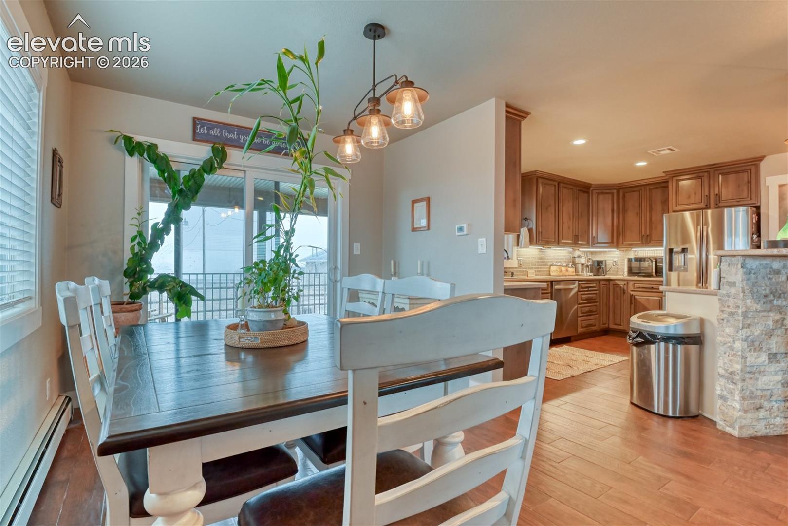 Dining room featuring light wood-style floors, a baseboard radiator, and recessed lighting
