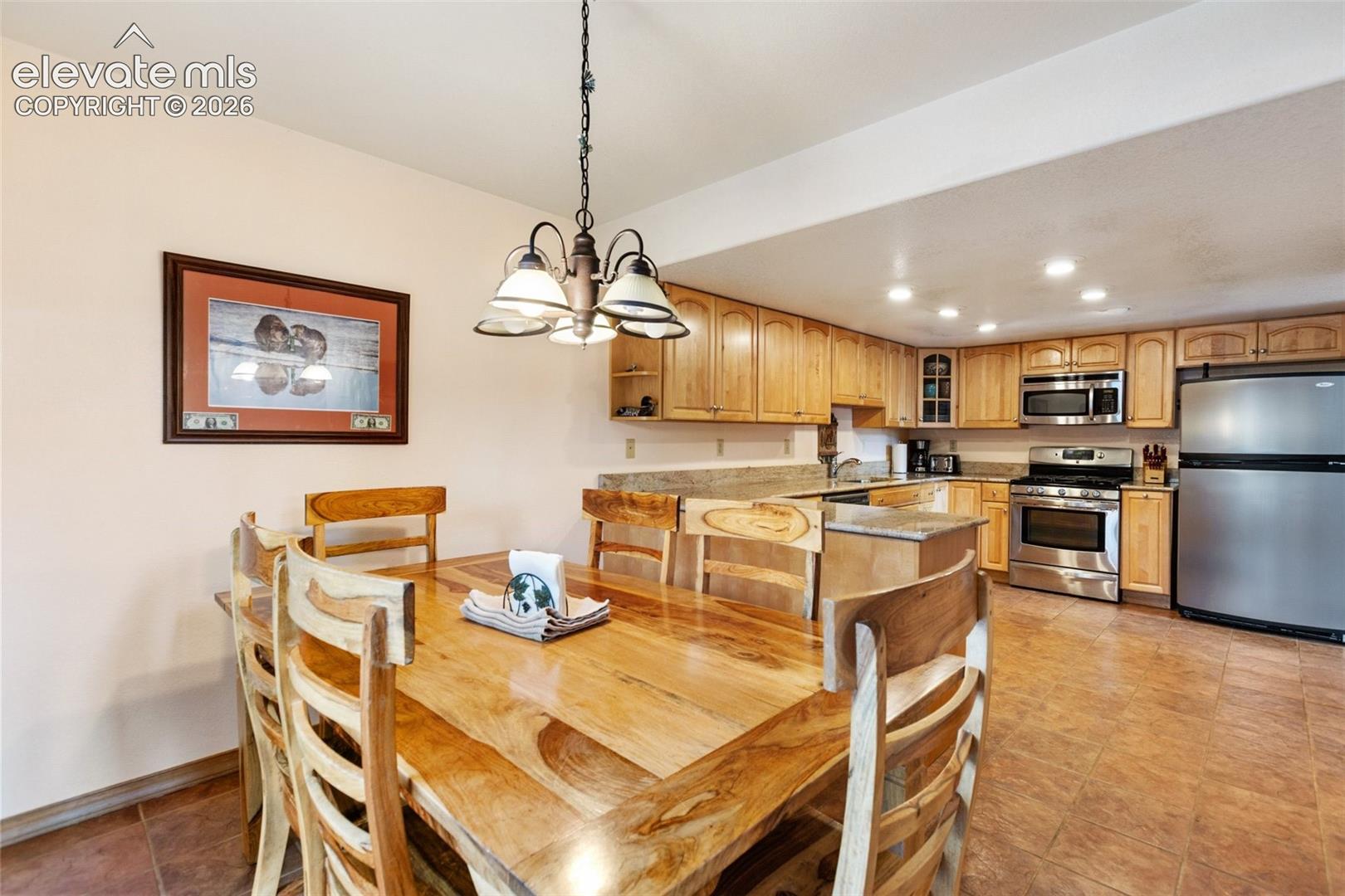 Well-appointed kitchen featuring wood-finish cabinetry, stainless steel appliances, and recessed lighting