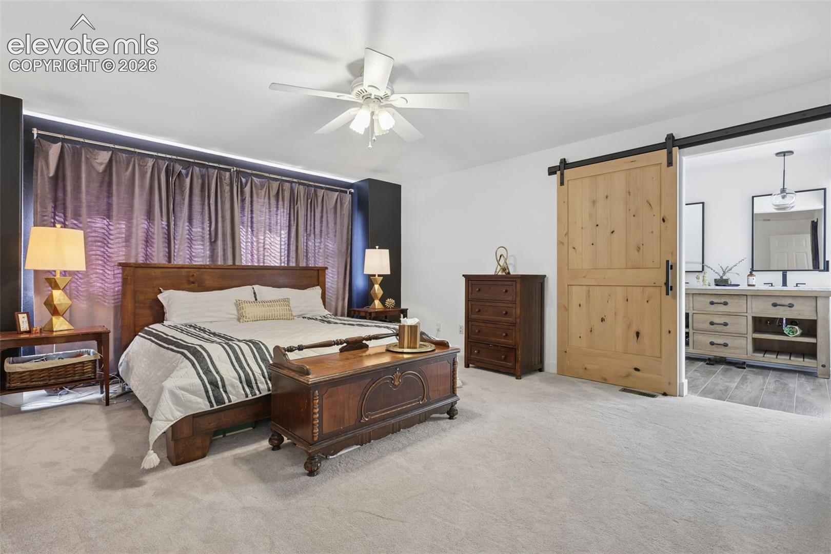 primary bedroom upper level with barn door leading into bathroom