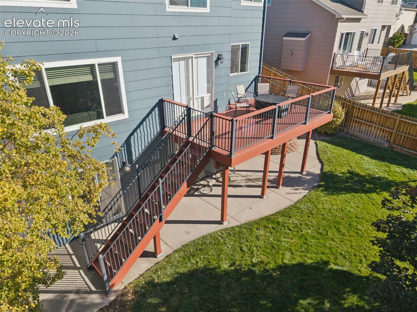Rear of home with main level deck and expanded patio off basement walk-out