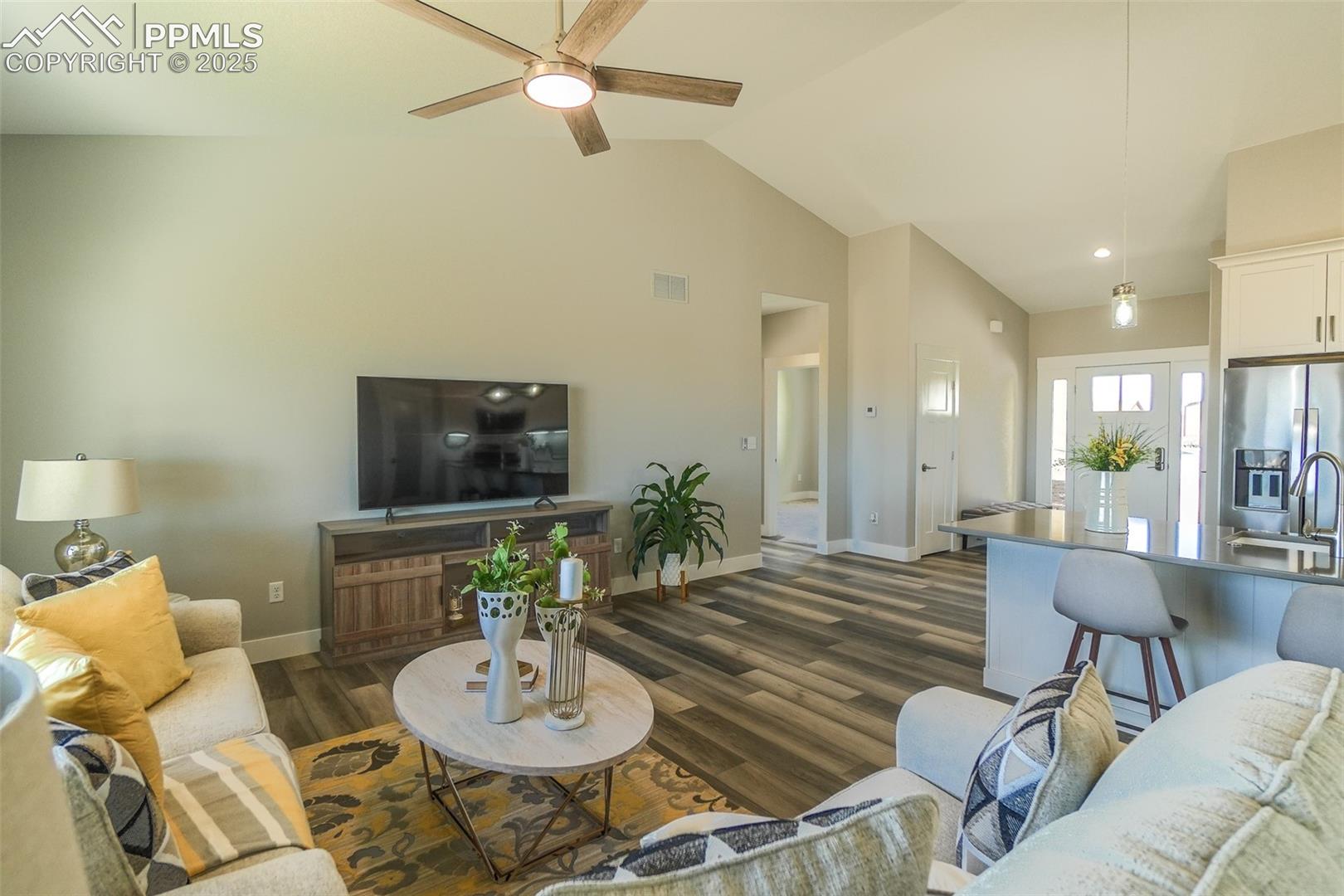 Living room featuring LTV / wood-style flooring, sink, high vaulted ceiling, and ceiling fan