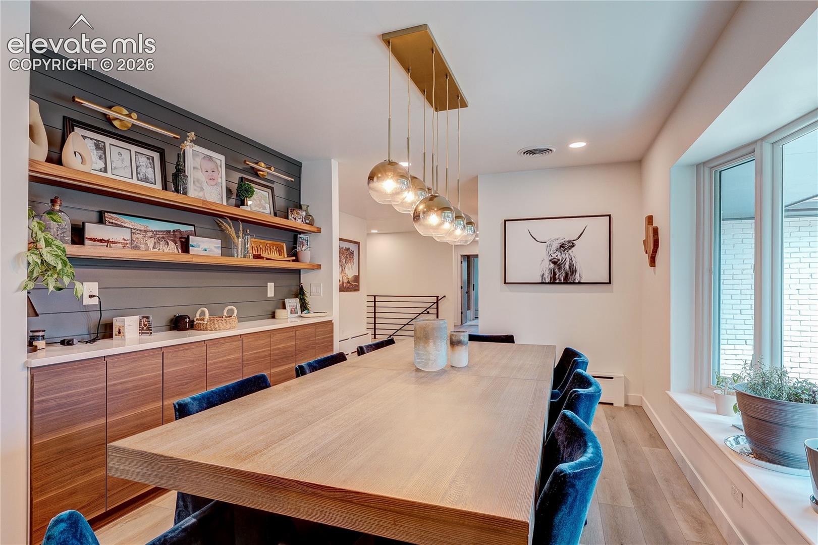 Built-in cabinetry with wood-finish doors and white countertops, shiplap wall detailing, and open wood shelving