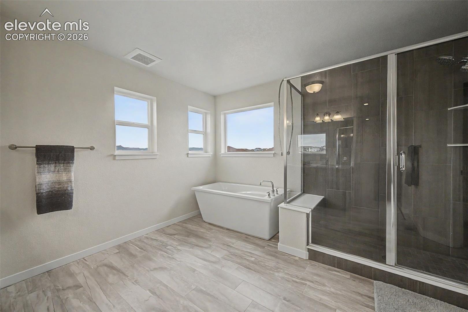 Wow! The roomy primary bath features a soaking tub and oversized, glass enclosed shower.