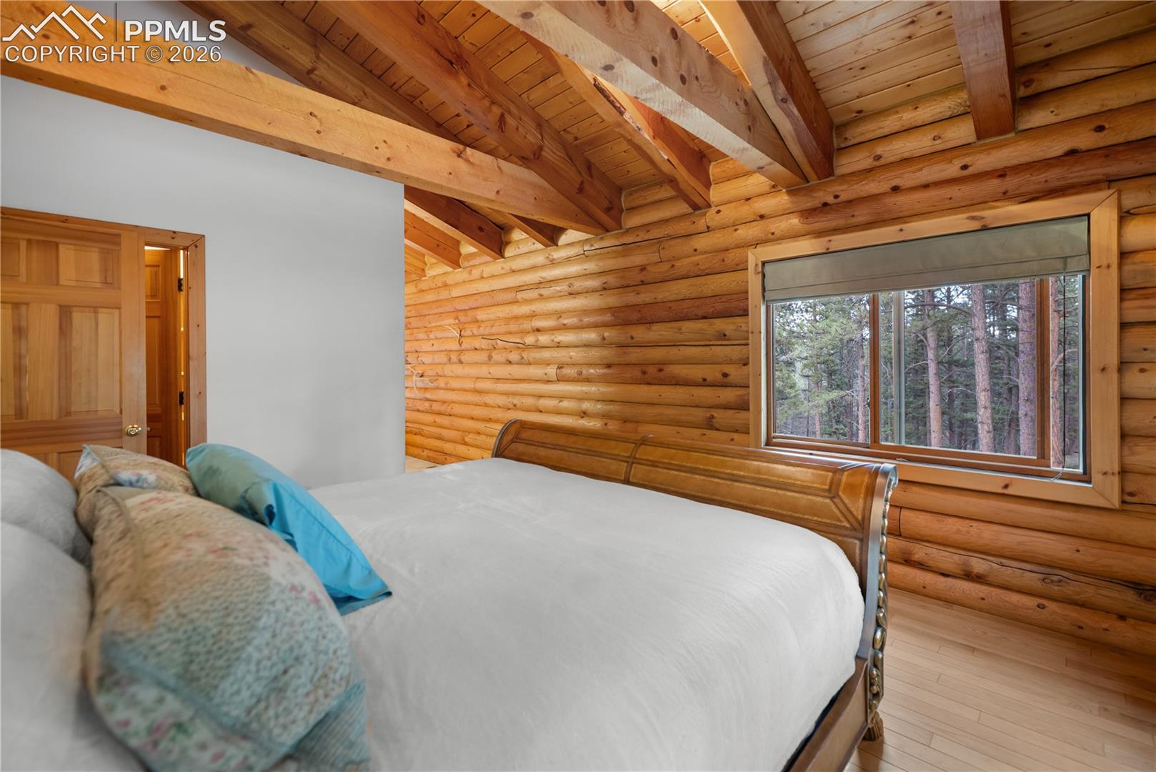 Bedroom featuring a wood ceiling with exposed beams, wood-type flooring, and log walls