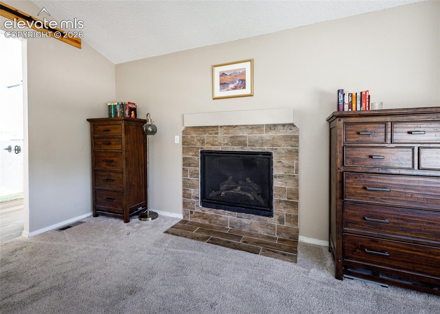 Gas fireplace with a tile surround and hearth, featuring a neutral mantel