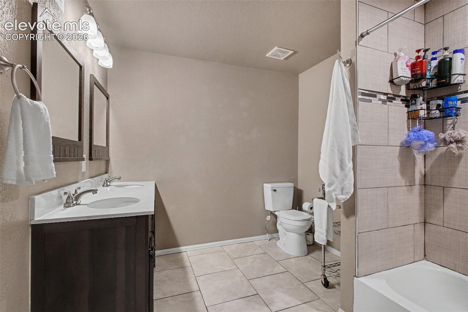 2nd full bath with dual sinks, tile flooring and tub/shower