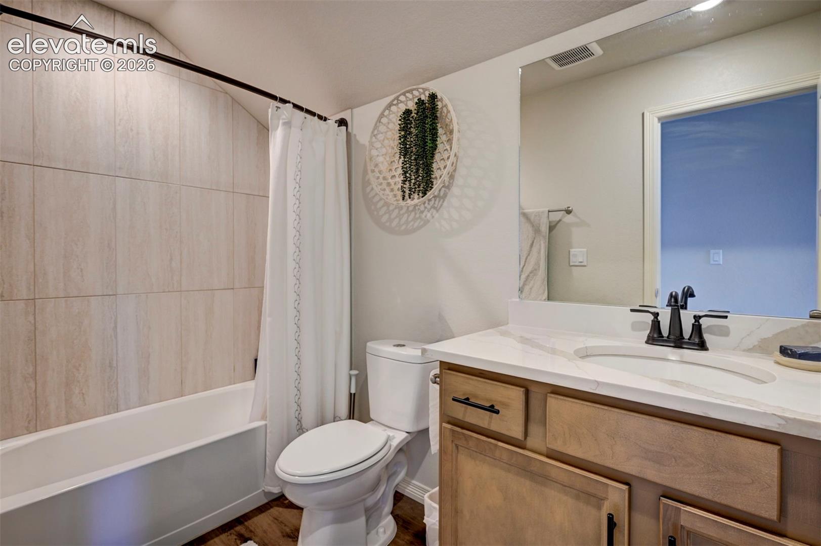 Full bathroom featuring a single vanity with stone countertop, undermount sink, and matte black faucet