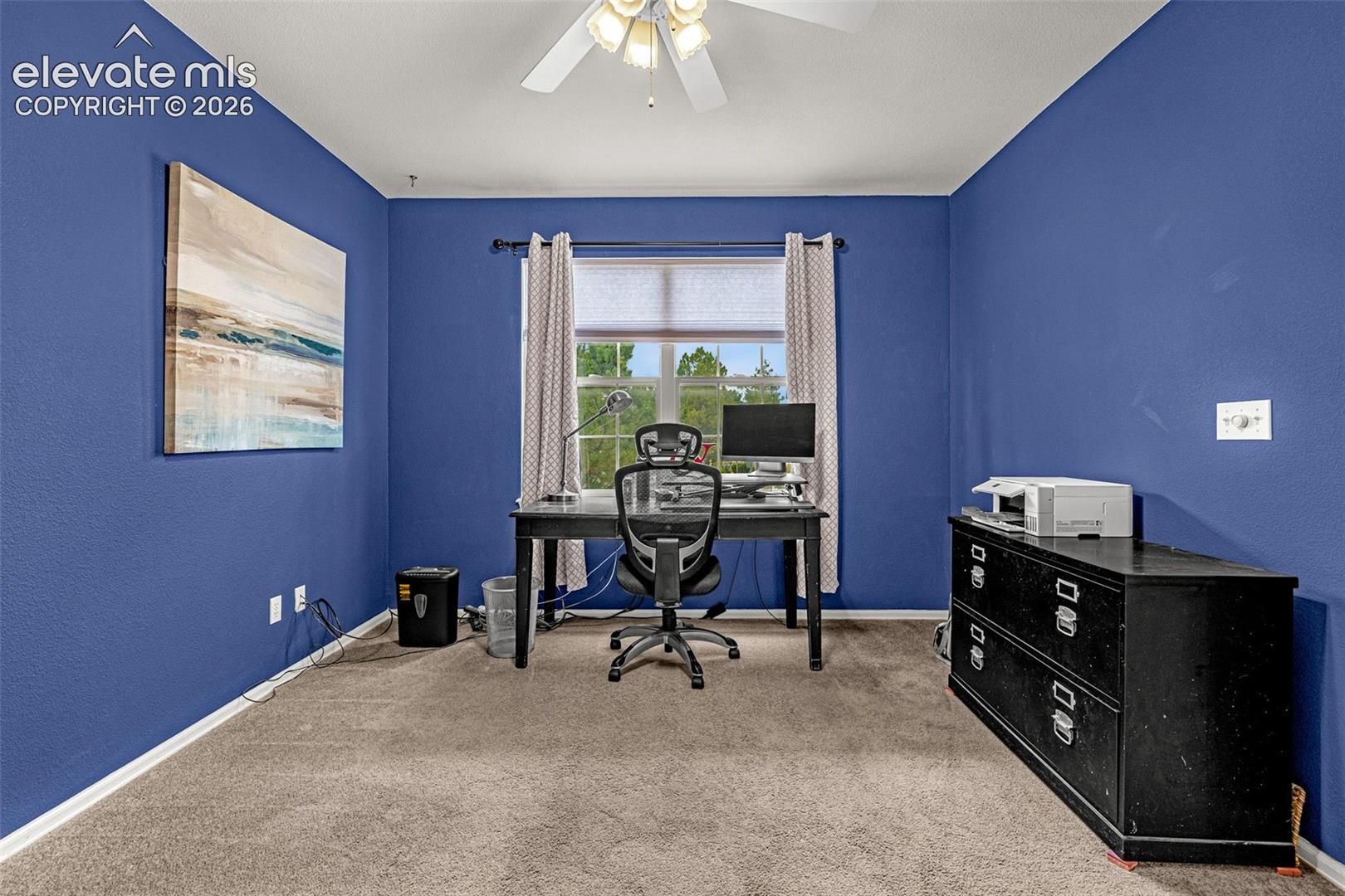 Carpeted room featuring a window with blinds, a ceiling fan with integrated lighting, and painted walls
