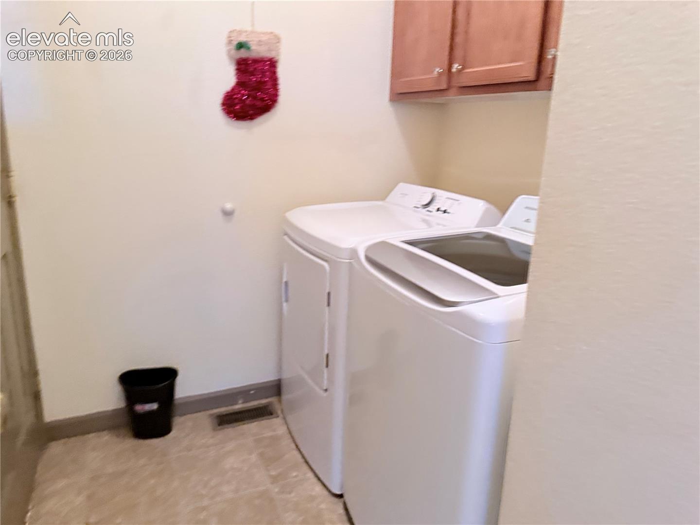 Dedicated laundry area featuring a top-load washing machine and a front-load dryer