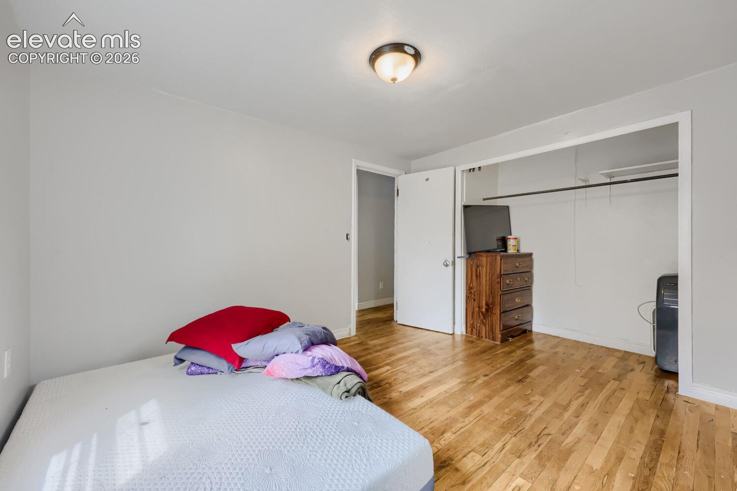 Wood-finish flooring, light gray wall paint, and a semi-flush mount ceiling light