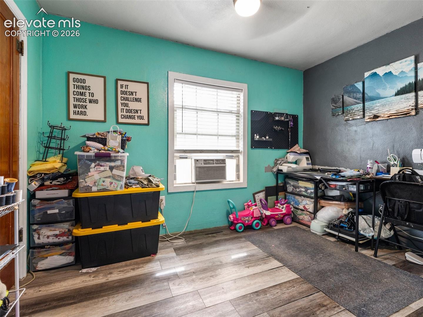 Wood-finish flooring with a window featuring blinds