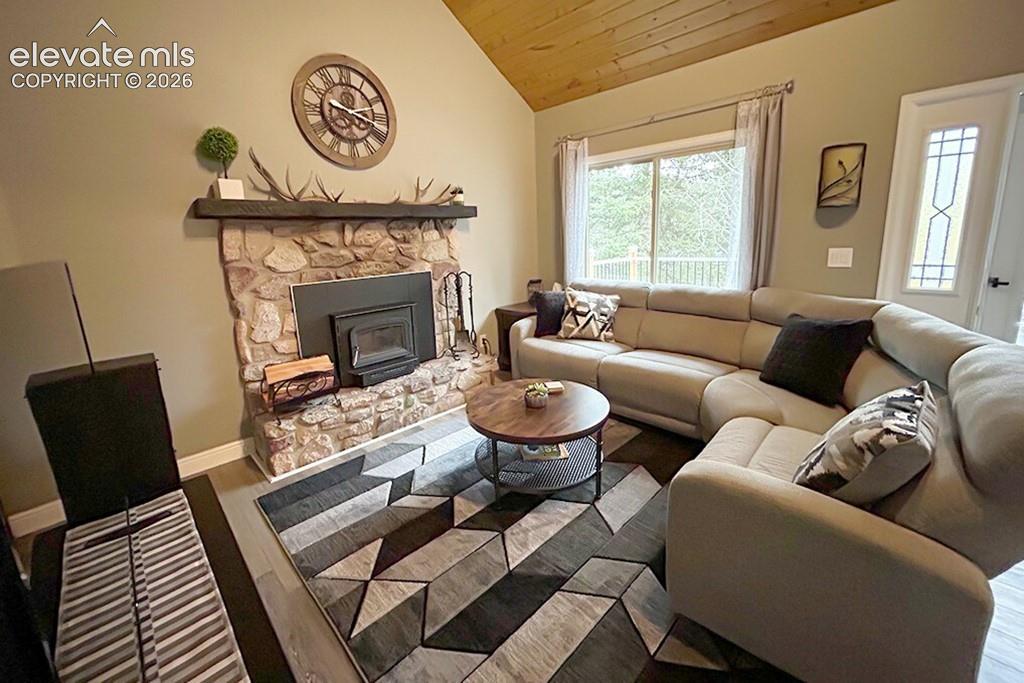 Family room featuring vaulted wood-finish ceiling, beautiful stone fireplace with a wood-burning insert.