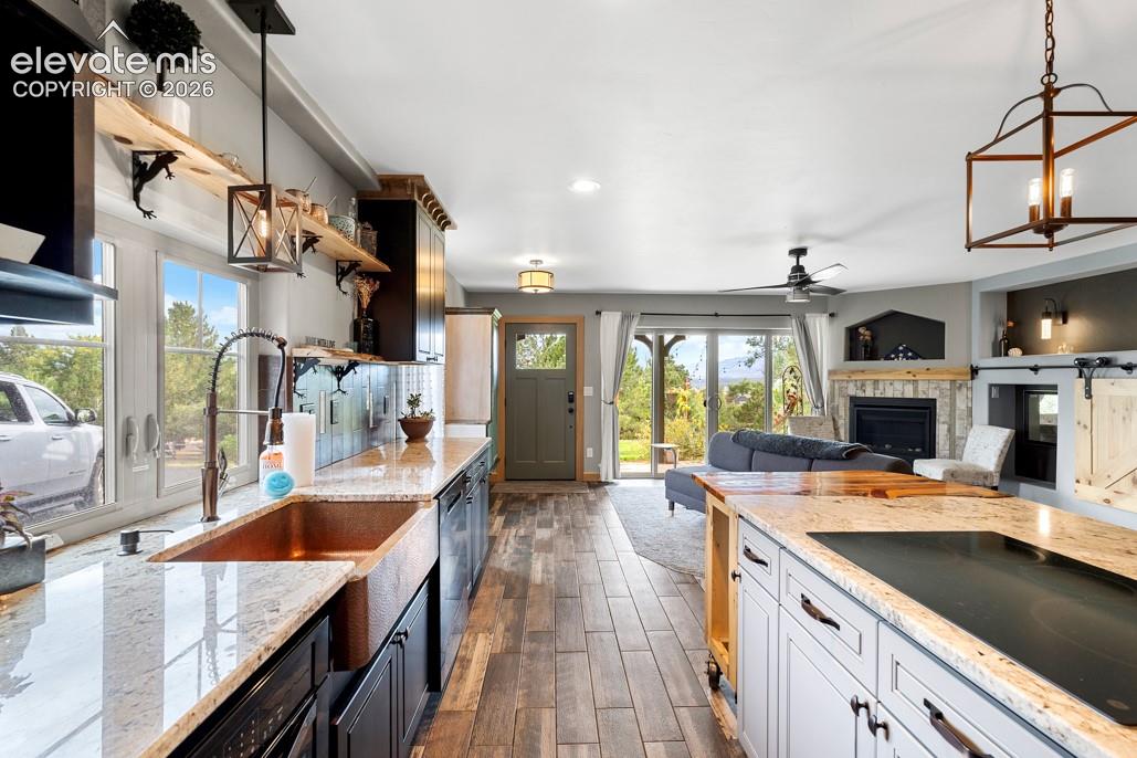 Kitchen featuring an apron-front sink, granite countertops, and wood-finish flooring