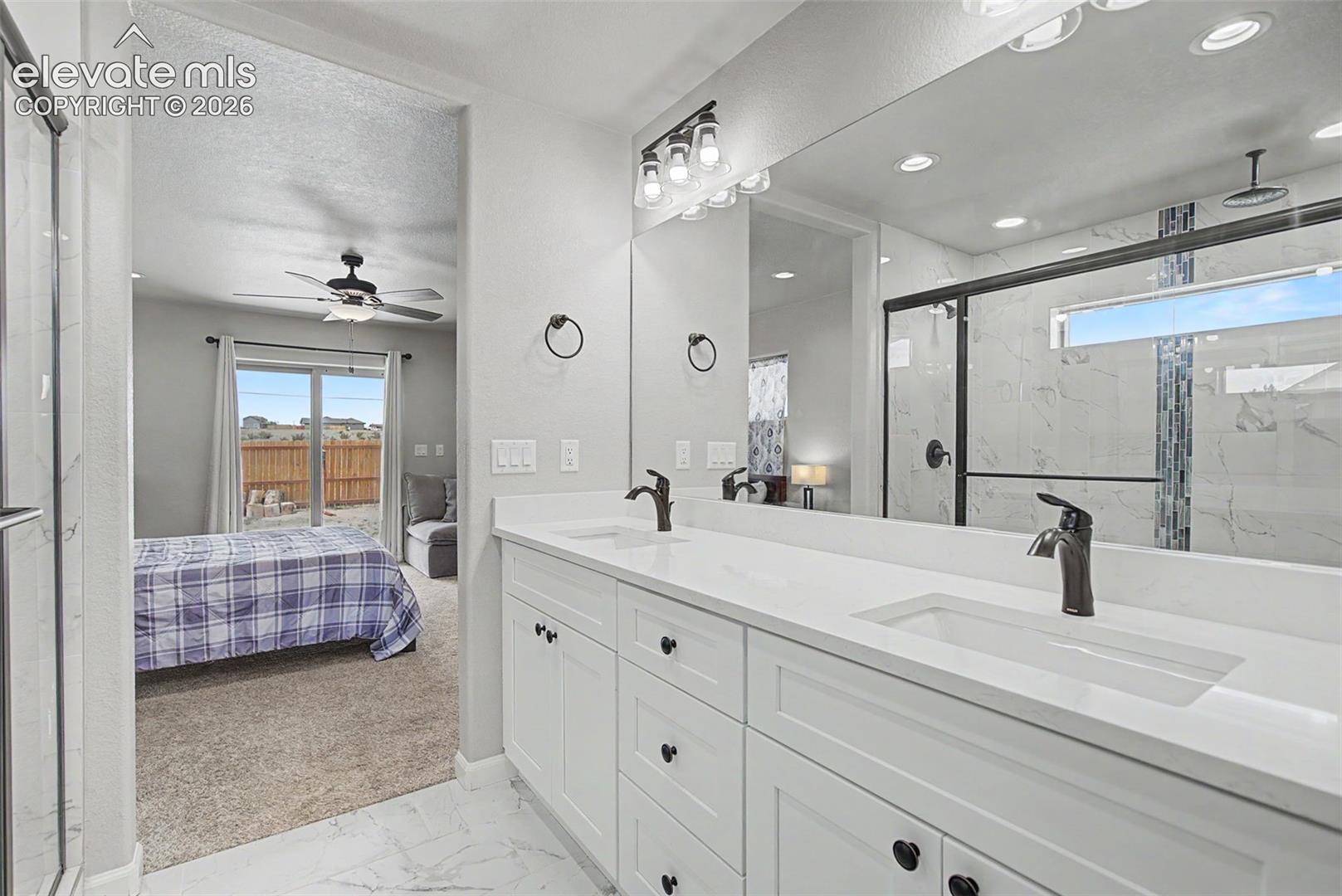 Contemporary bathroom featuring a double vanity with white cabinetry, integrated sinks, and dark bronze fixtures