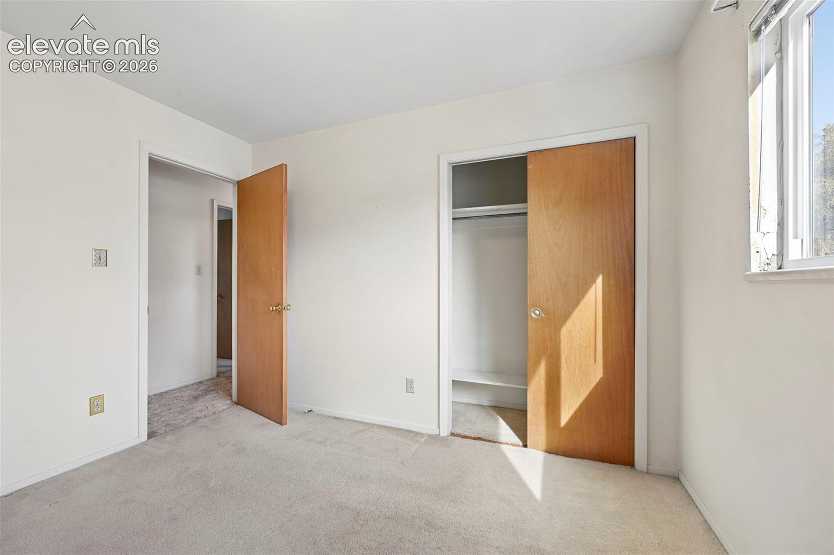 Bedroom 2 with wood-finish interior doors, and a reach-in closet with built-in shelving