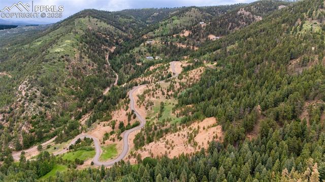 Aerial view of property's location with mountains and a heavily wooded area
