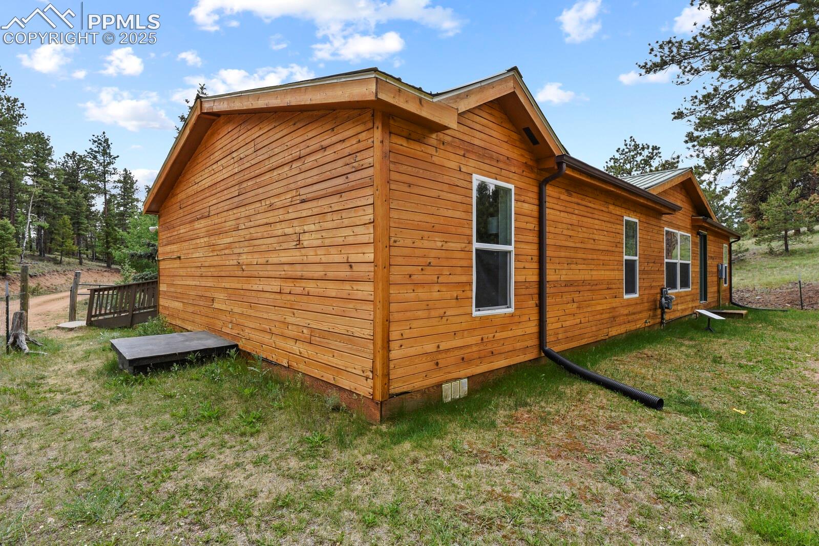 View of home's exterior with crawl space and a lawn