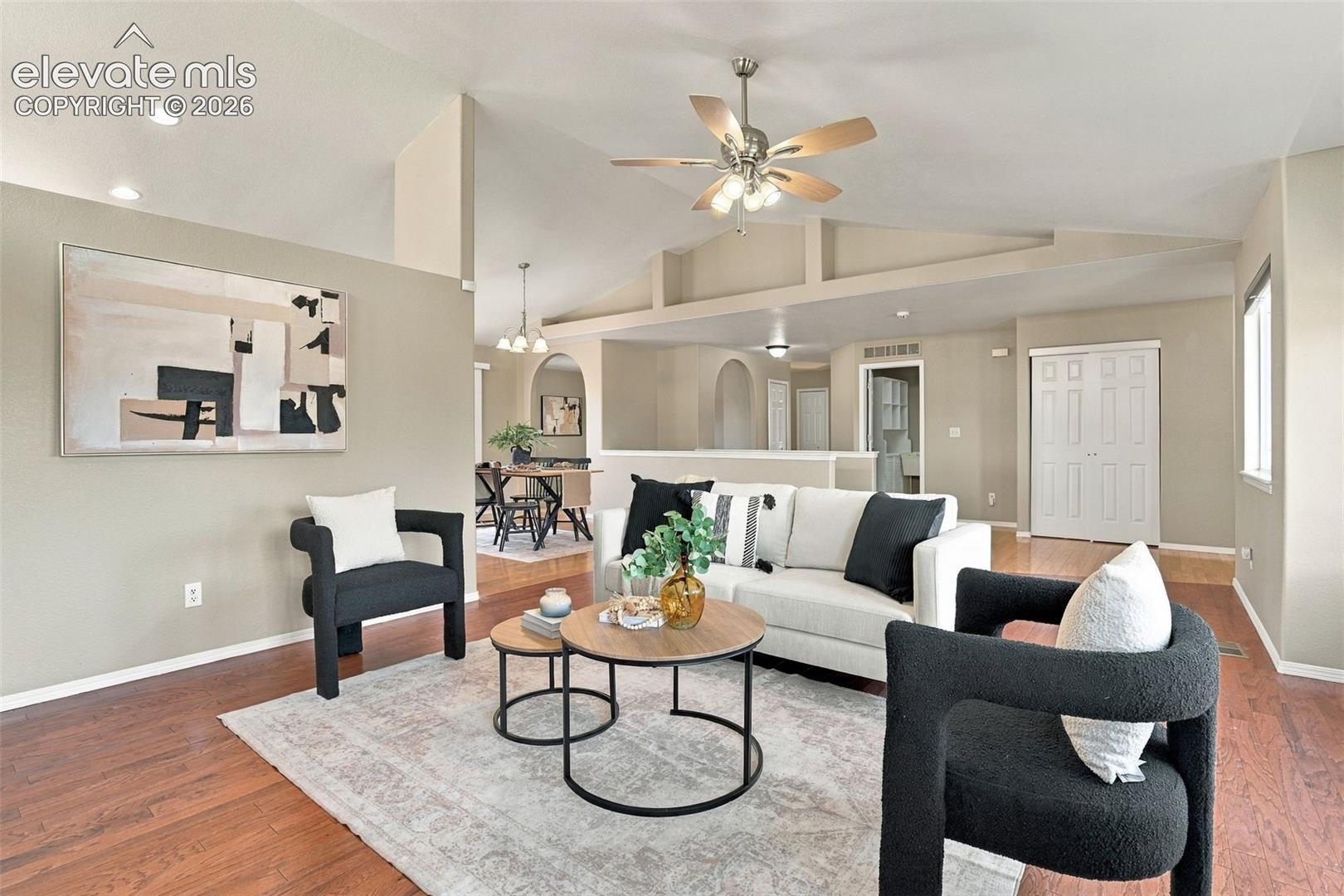 Vaulted ceiling with a ceiling fan, hardwood flooring, recessed lighting, and archways