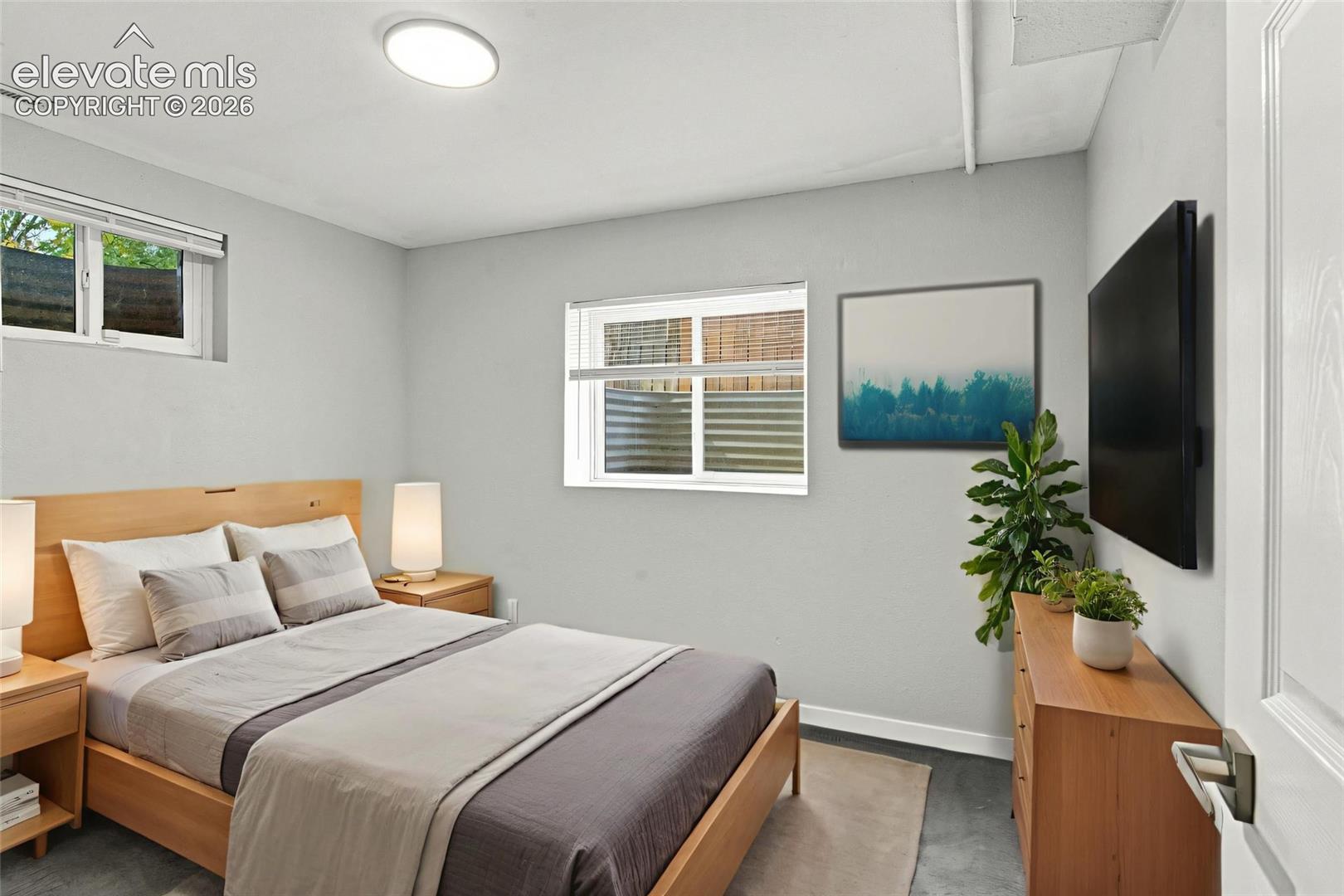 Room interior featuring neutral wall tones, two sliding windows, and a flush-mount overhead light fixture