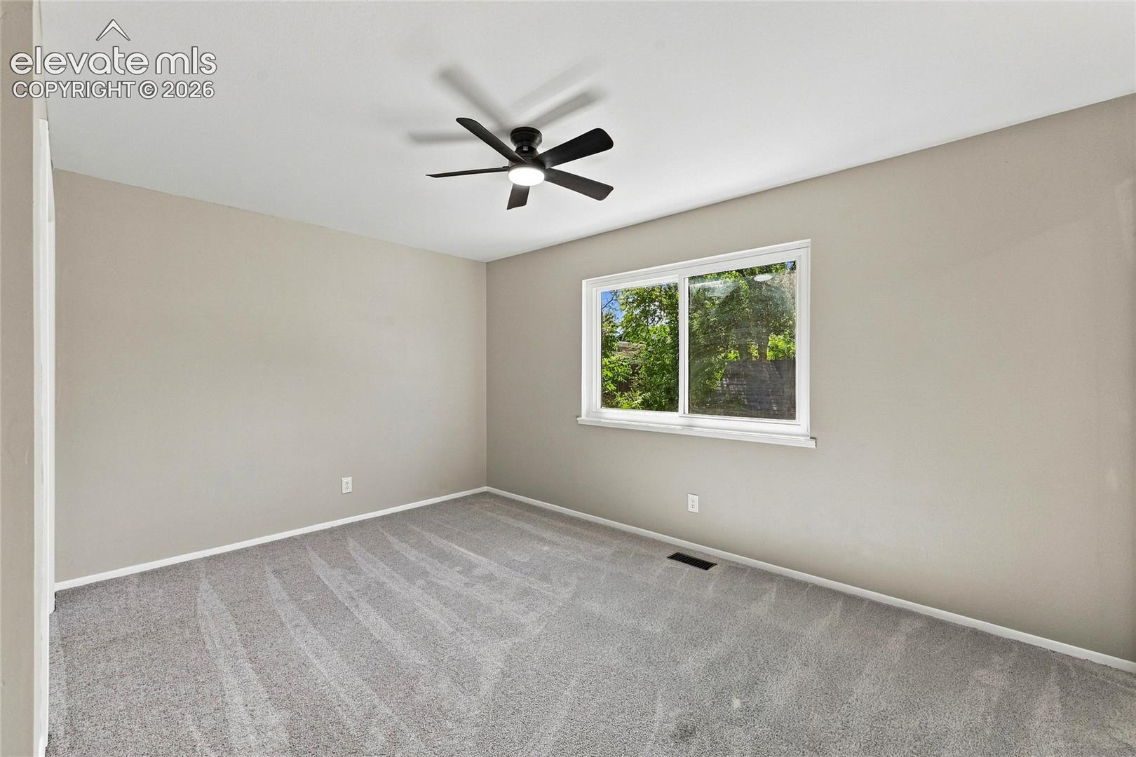 Recessed lighting, ceiling fan, neutral wall tones, window with natural light, and gray carpet