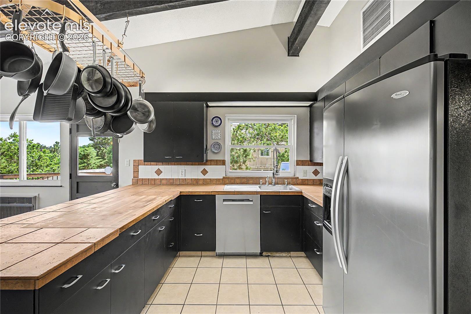 The kitchen highlights its abundant counter space and the continuation of those signature exposed ceiling beams.