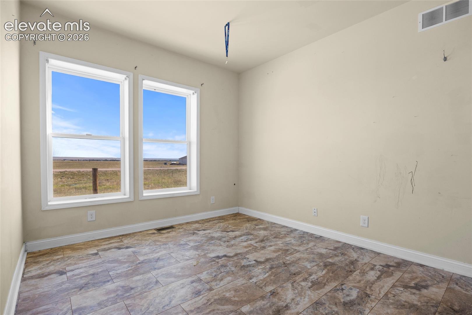 Room interior featuring tile flooring and dual windows with natural lighting