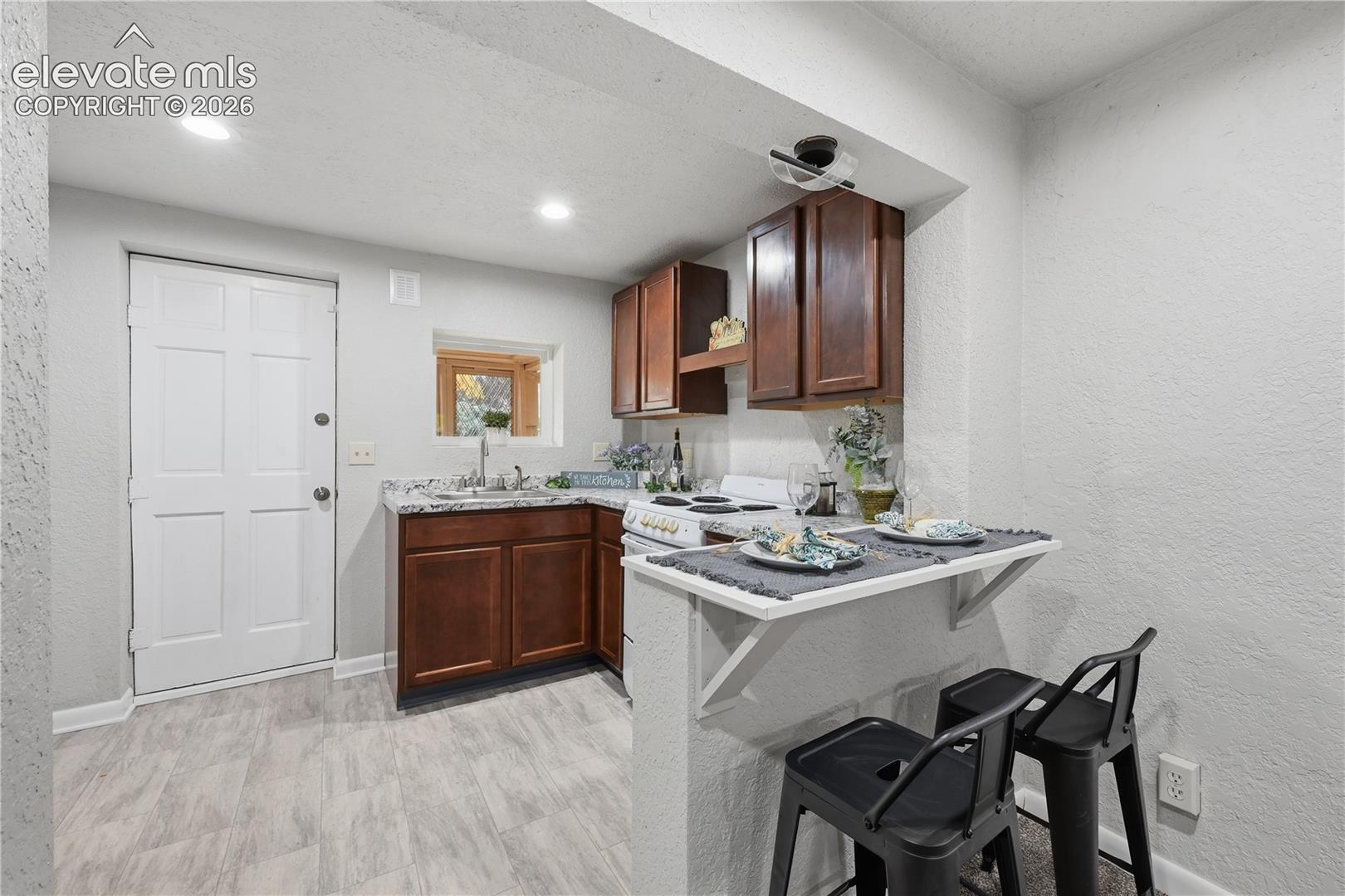 A fully functional kitchen in the apartment. With refrigerator and stove. The door leads to the front yard.