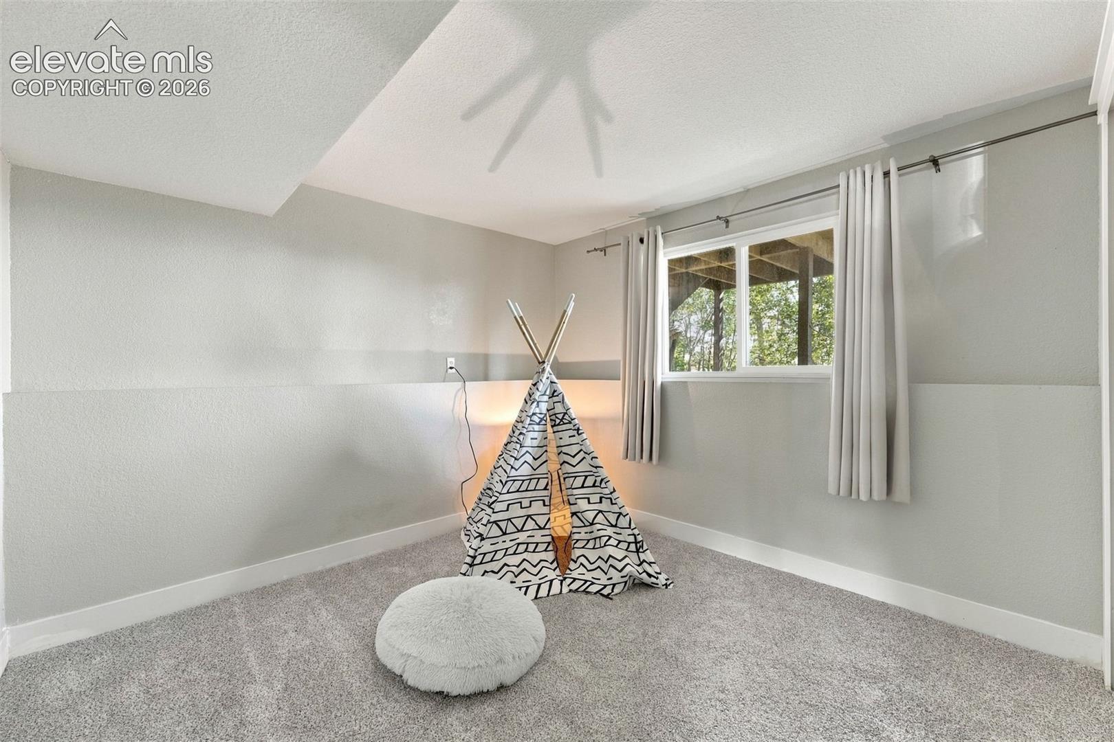 Recessed window with white trim, gray textured walls, and light gray carpeting