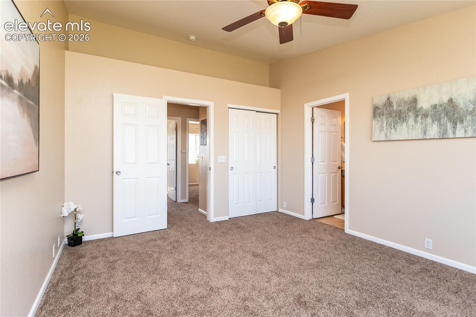 Retreat to a tranquil primary bedroom complete with neutral color tones, new carpeting, and double closet doors