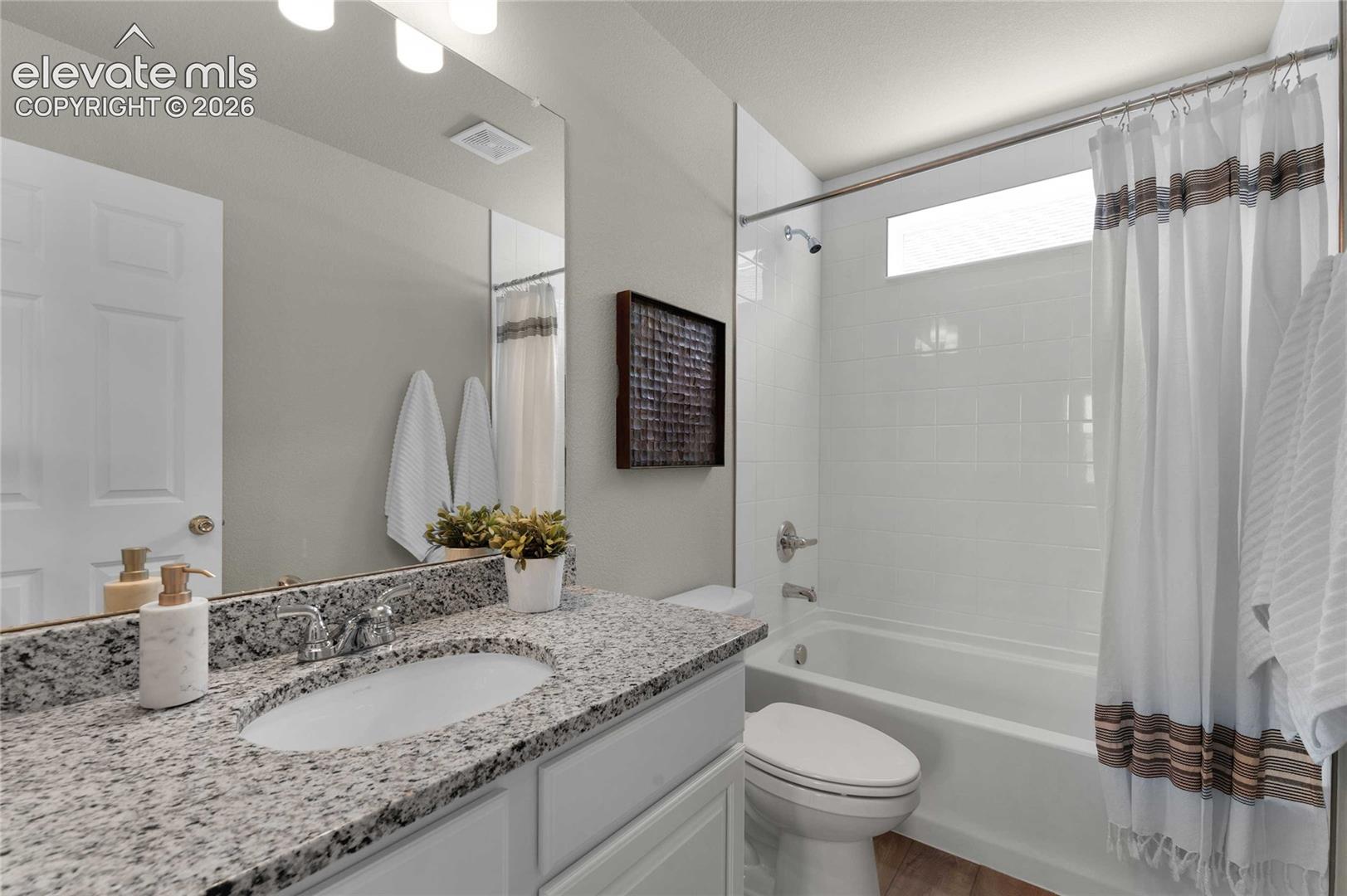 White vanity with a speckled countertop, undermount sink, and chrome fixtures
*photos of a model home*