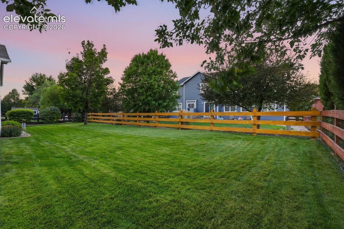 large fenced in yard with lush green grass