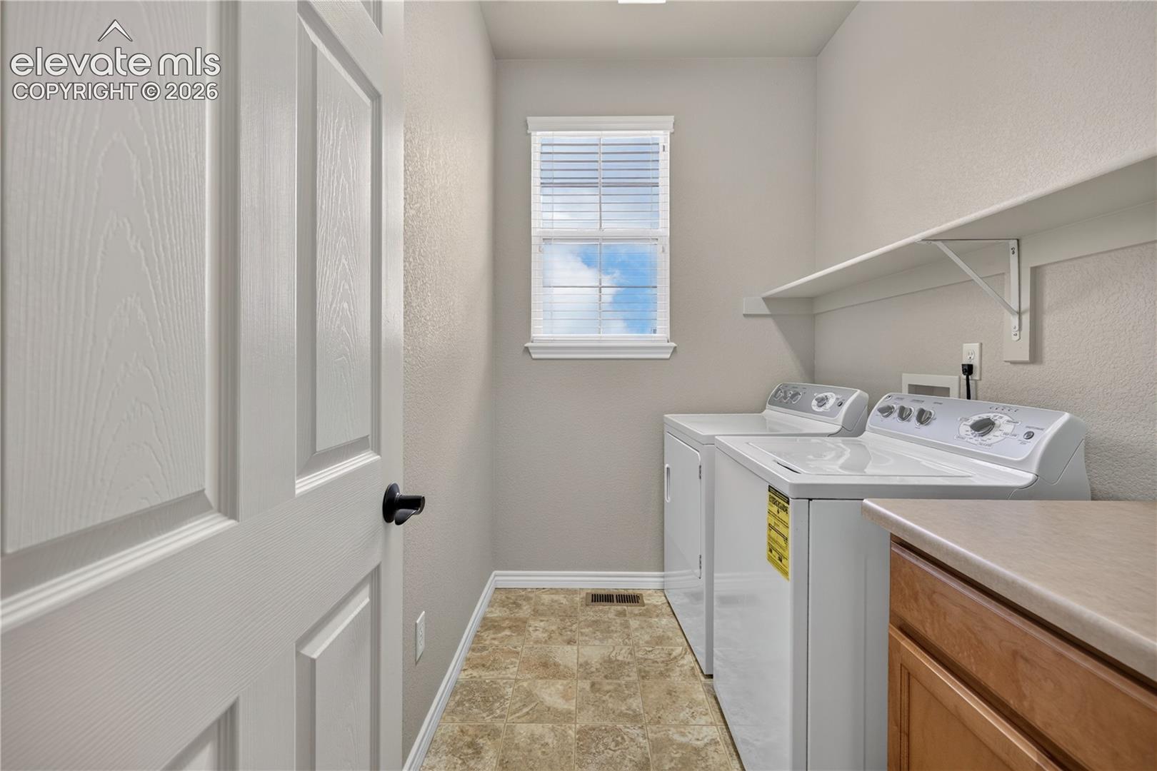 Laundry on upper level by the bedrooms. with built in cabinet and shelf.