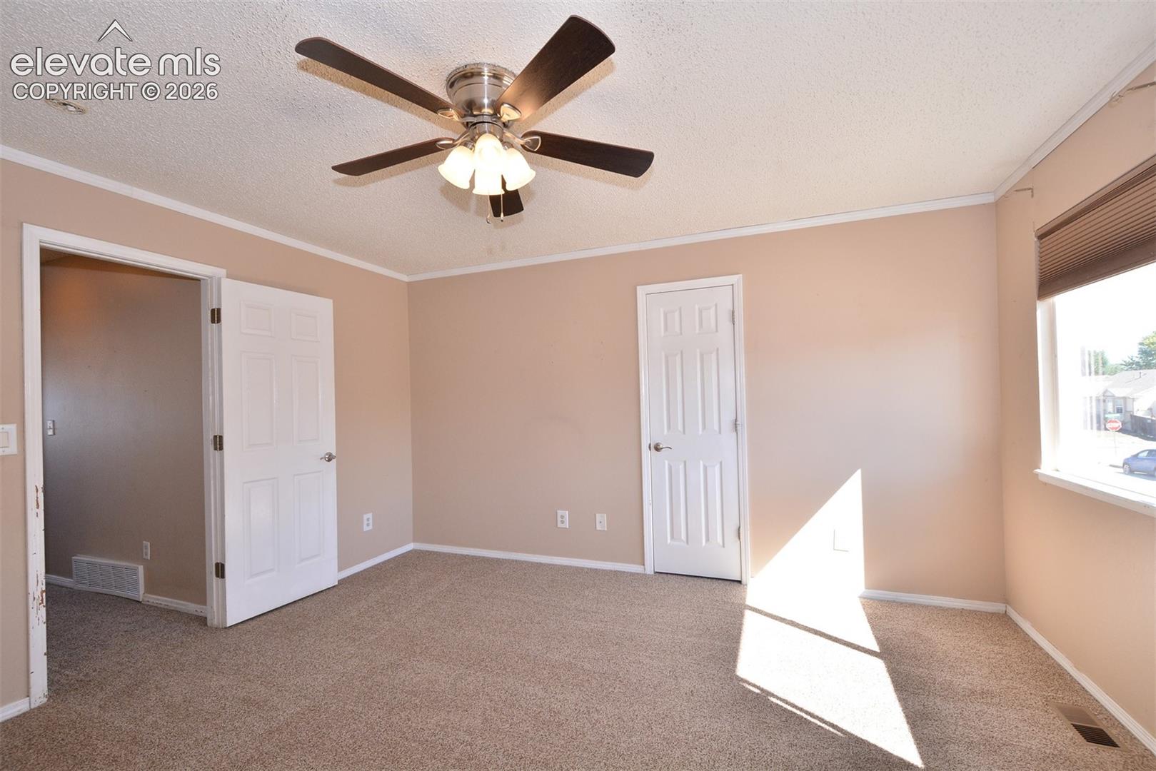 Neutral tone wall finishes, white trim, and a ceiling fan with integrated lighting