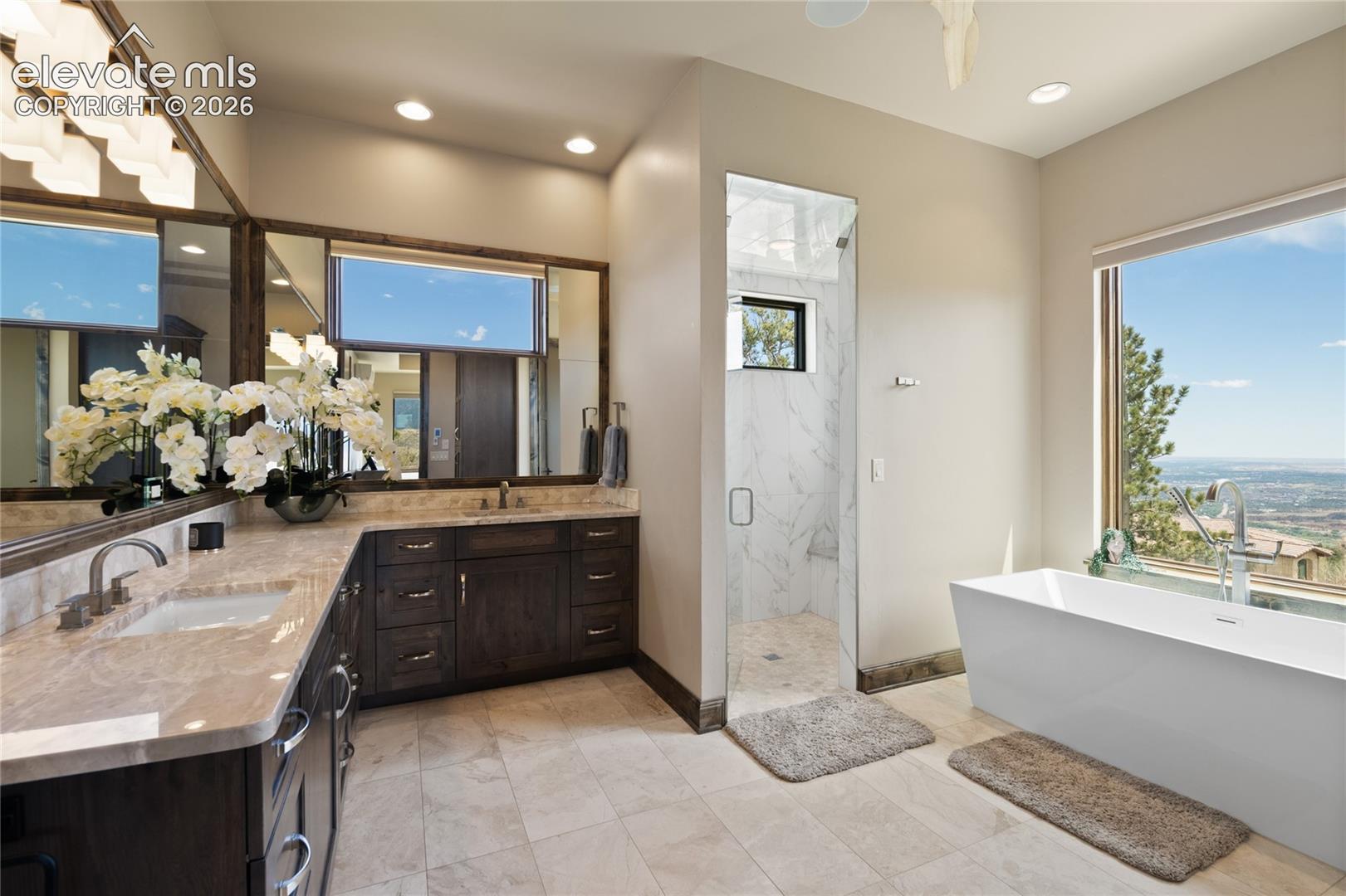 Your own personal spa, no appointment necessary. Resort-caliber primary bath with heated marble flooring, dual vanities, soaking tub, walk-in steam shower, and panoramic city light views.