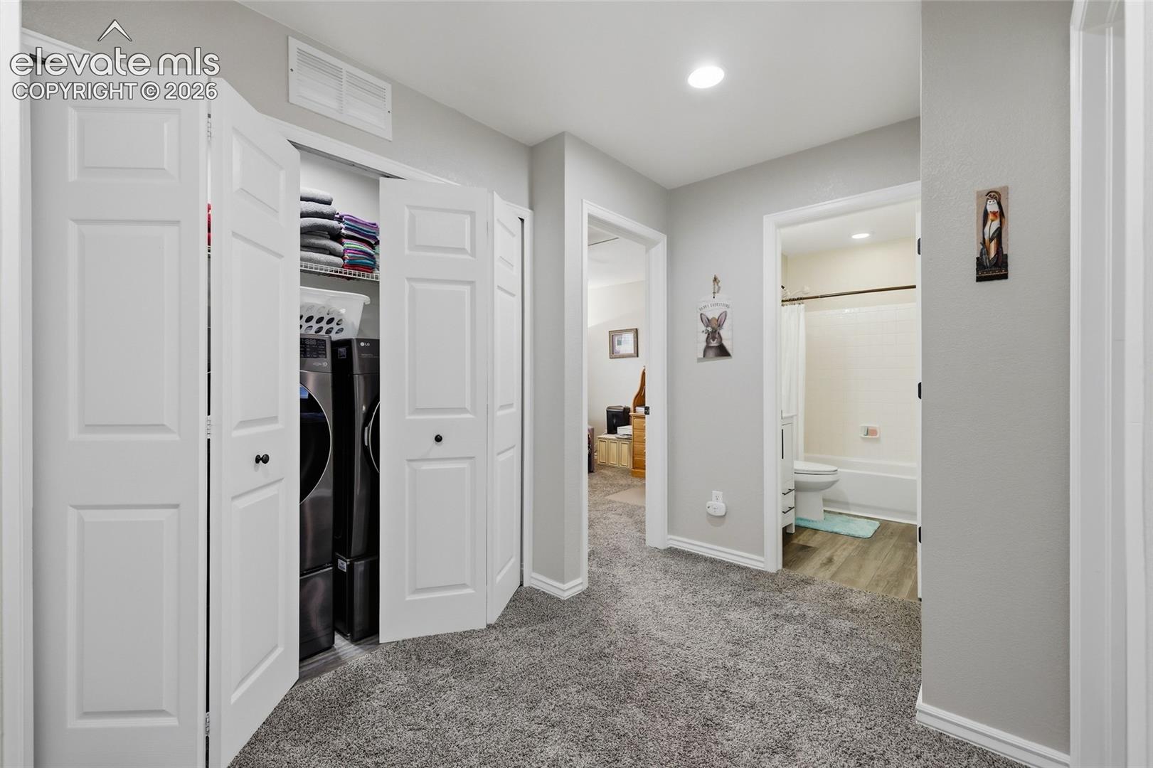 Upper landing, featuring gray wall paint, gray carpeting, recessed ceiling lighting, and white trim