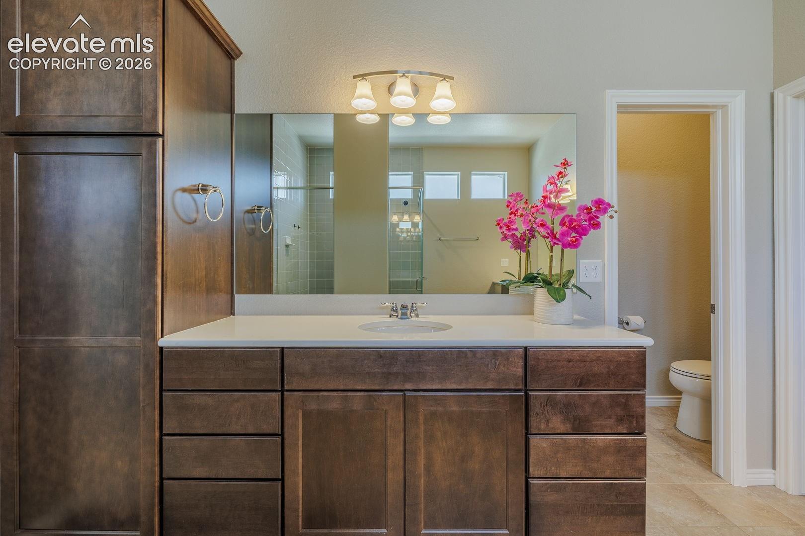 main bedroom with double sinks, walk in clset and access to laundry room
