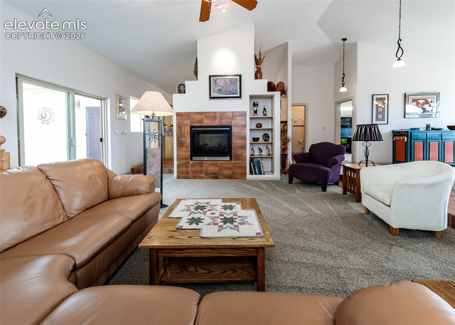 Living room also offers a dual side fireplace with a tiled surround and integrated built-ins.