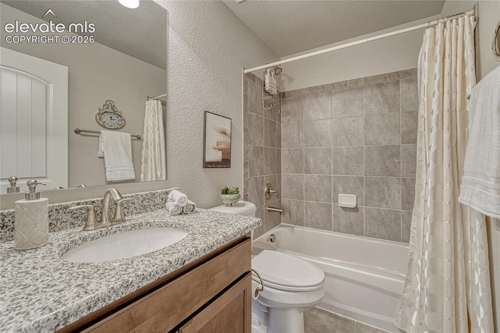 The basement bathroom adds convenience with a granite vanity, neutral finishes, and a classic tub-shower combination.