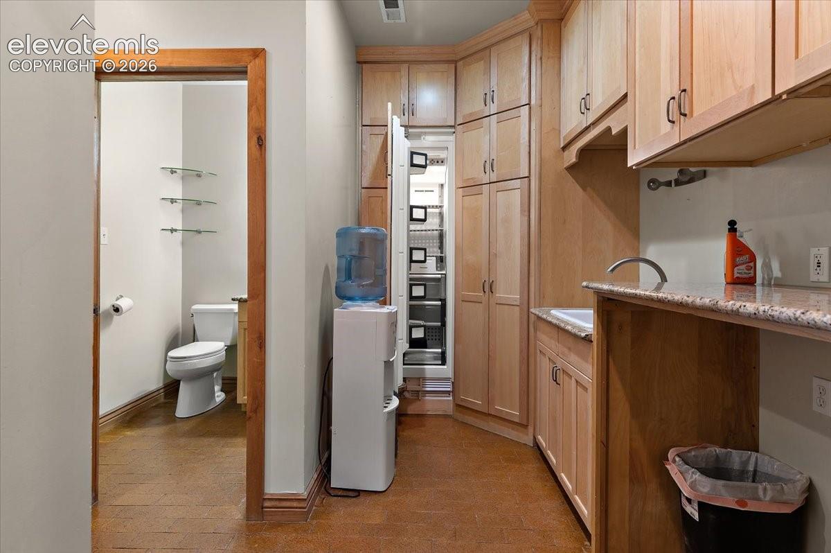 6 ft by 10 foot laundry room has utility sink, small built in Thermador freezer and adjoins the mud room.