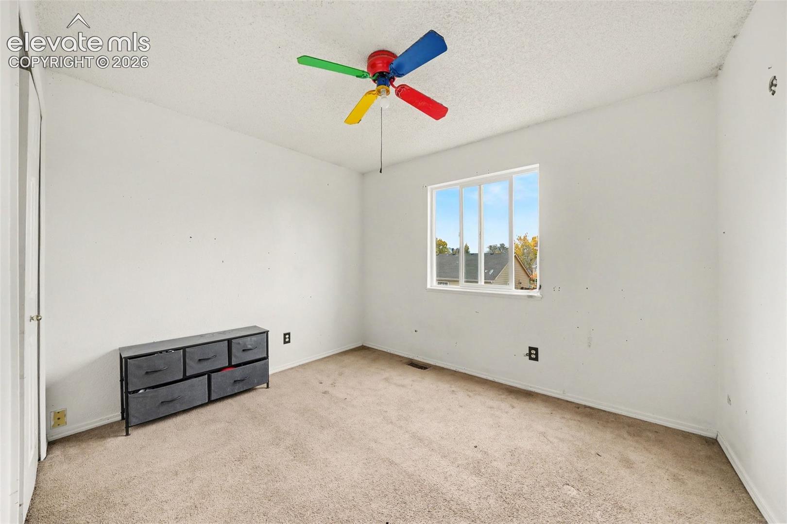 Neutral-tone carpeting and a single-pane sliding window