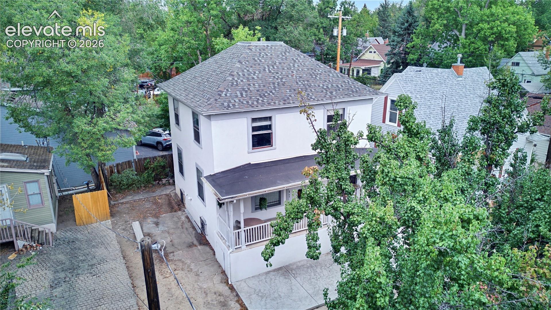 Two-story exterior with a shingle roof, covered porch, and white railings
